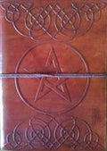 Brown leather journal with pentagram design on a wooden surface