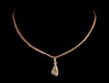 Gold necklace with a hand-shaped pendant on a mannequin