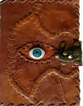 A brown leather journal with a unique stitched eye design and a brass spiral clasp closure, shown against a plain white background.