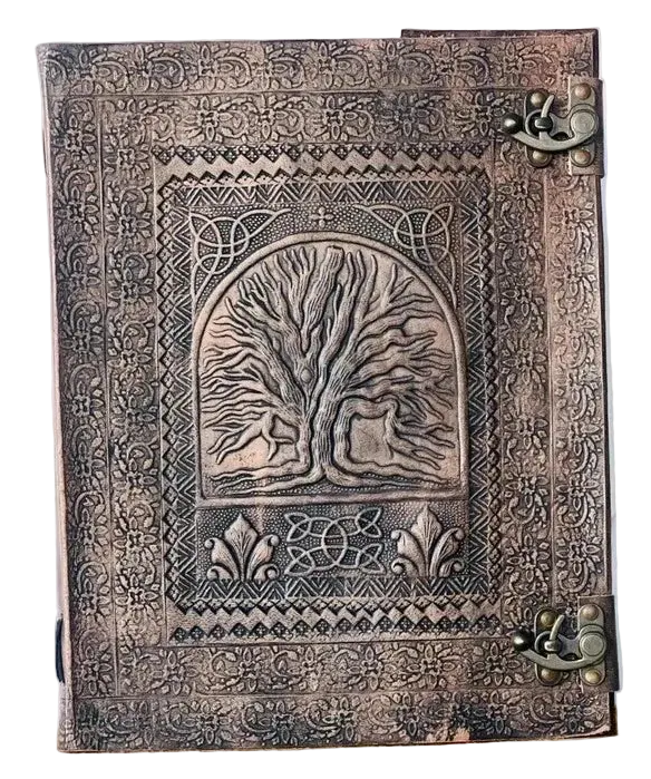 A rectangular embossed leather journal with a tree of life design on the cover, 