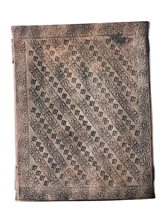 A rectangular leather journal with intricate hand-carved geometric patterns